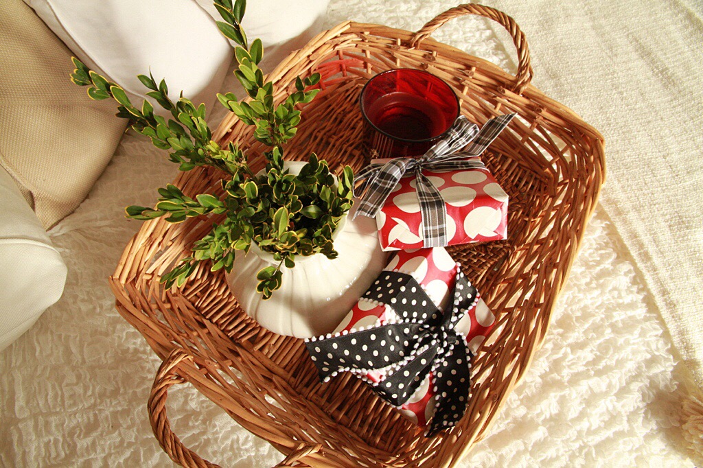 A wicker basket filled with presents and a green plant.