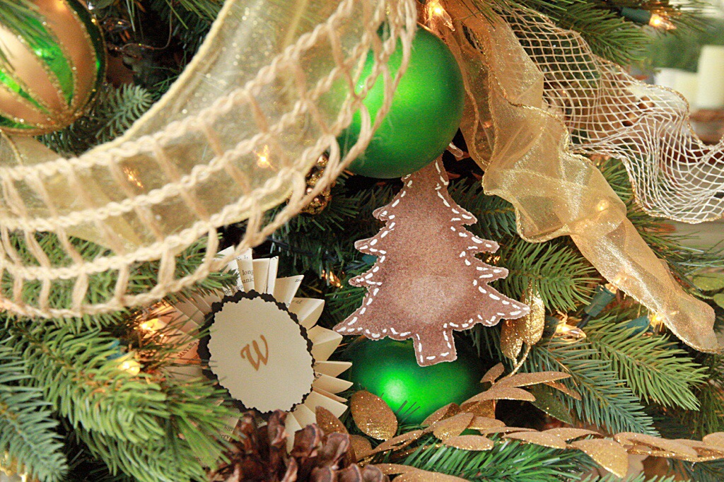 Green and gold ornaments on the Christmas tree.