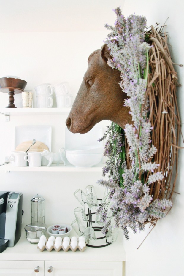 DIY lavender wreath hanging around the head of a deer on the wall.