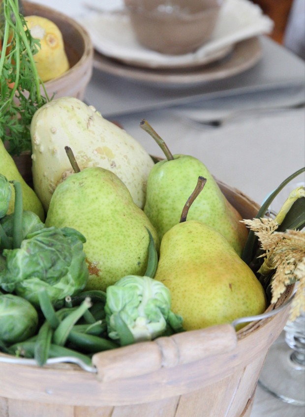 Pears and brussell sprouts in a wooden bucket.