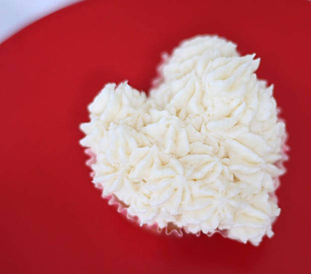 Up close picture of the iced muffin on a red cake stand.