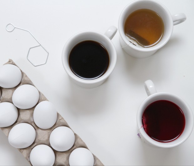 Cups of tea on the counter beside the eggs.