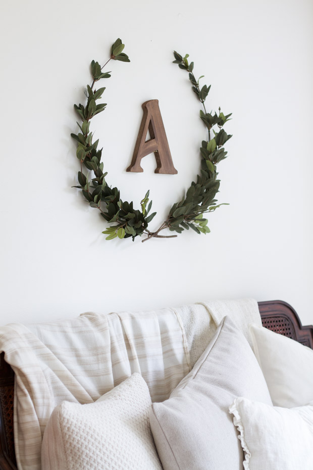 Two sprigs of laurel in a U shape with the letter A on the wall.