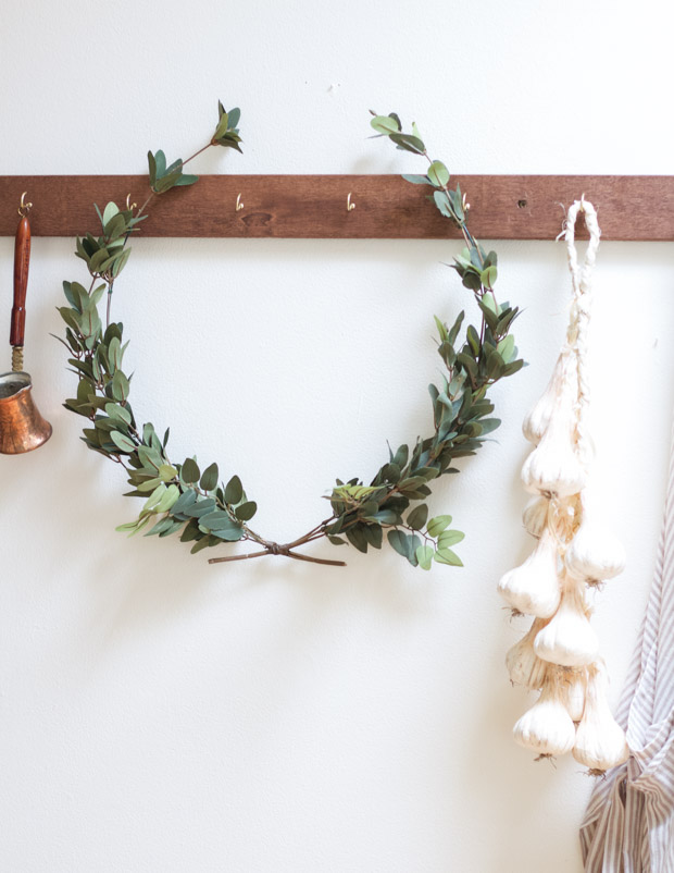 A DIY laurel wreath hanging on a coat rail.