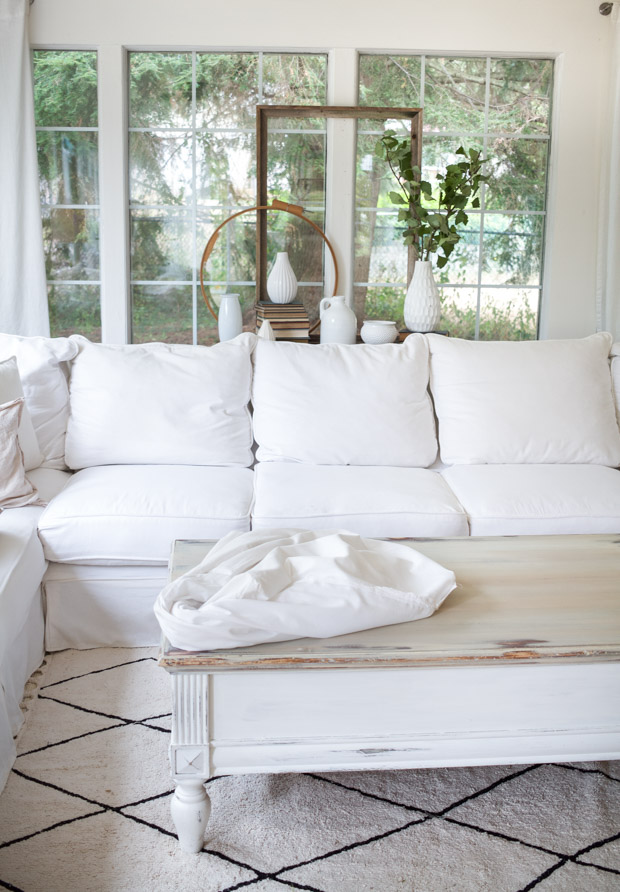 Fitting the white sheets together on the couch.