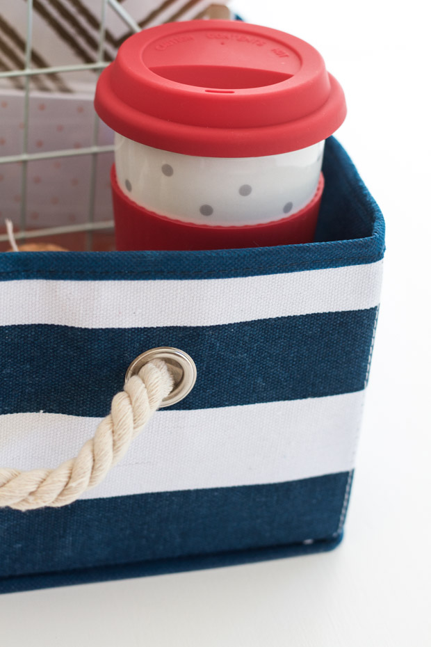 The red and white cup in the striped blue and white basket.