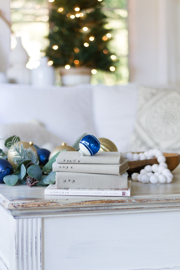 Four books on the coffee table, Peace, Joy, Love and a touch of farmhouse charm.