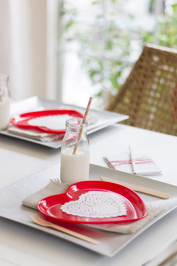 Red paper plate with a white doily on the table.