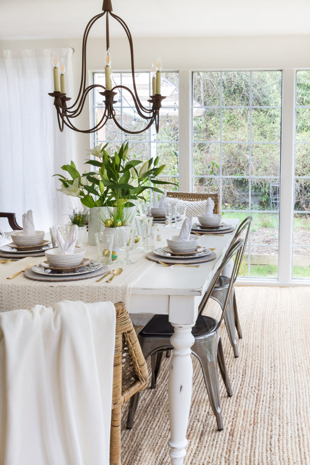 A large floor to ceiling window by the table decorated for Easter.