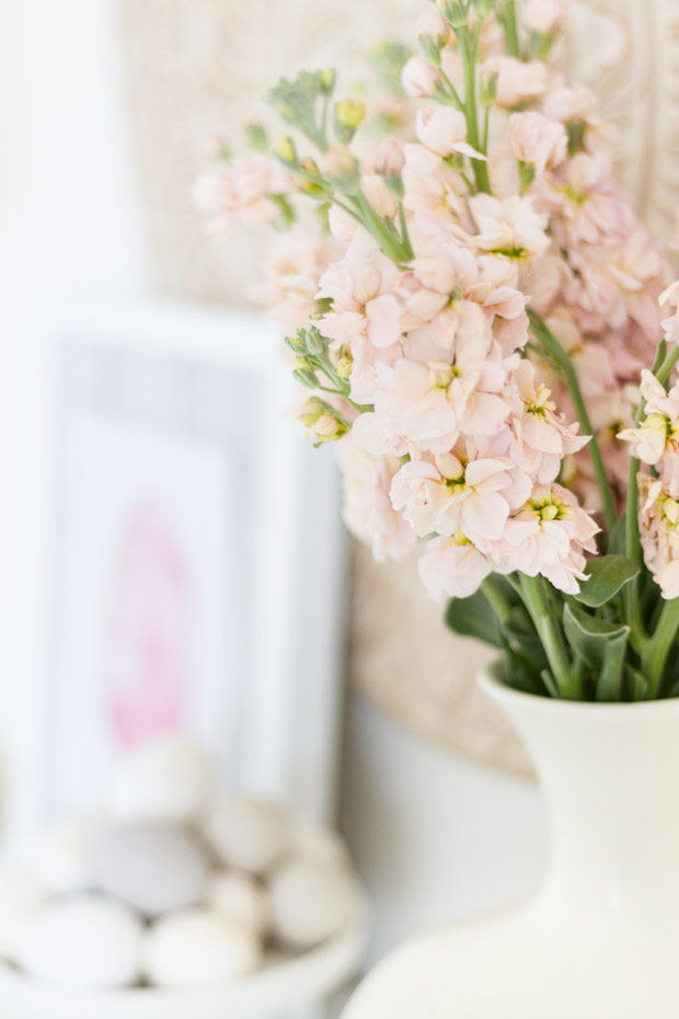 White and blush pink flowers in a white vase on the desk.