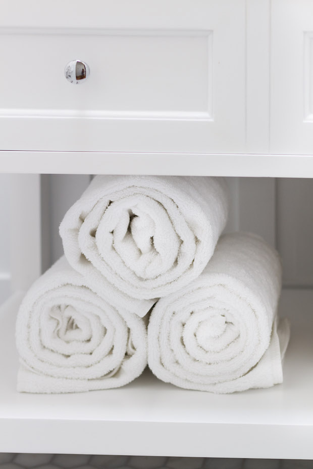 White rolled up towels in the vanity.