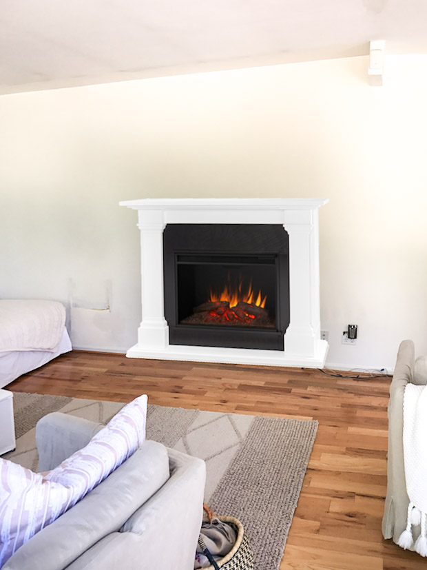 Electric fireplace with faux logs in living room.