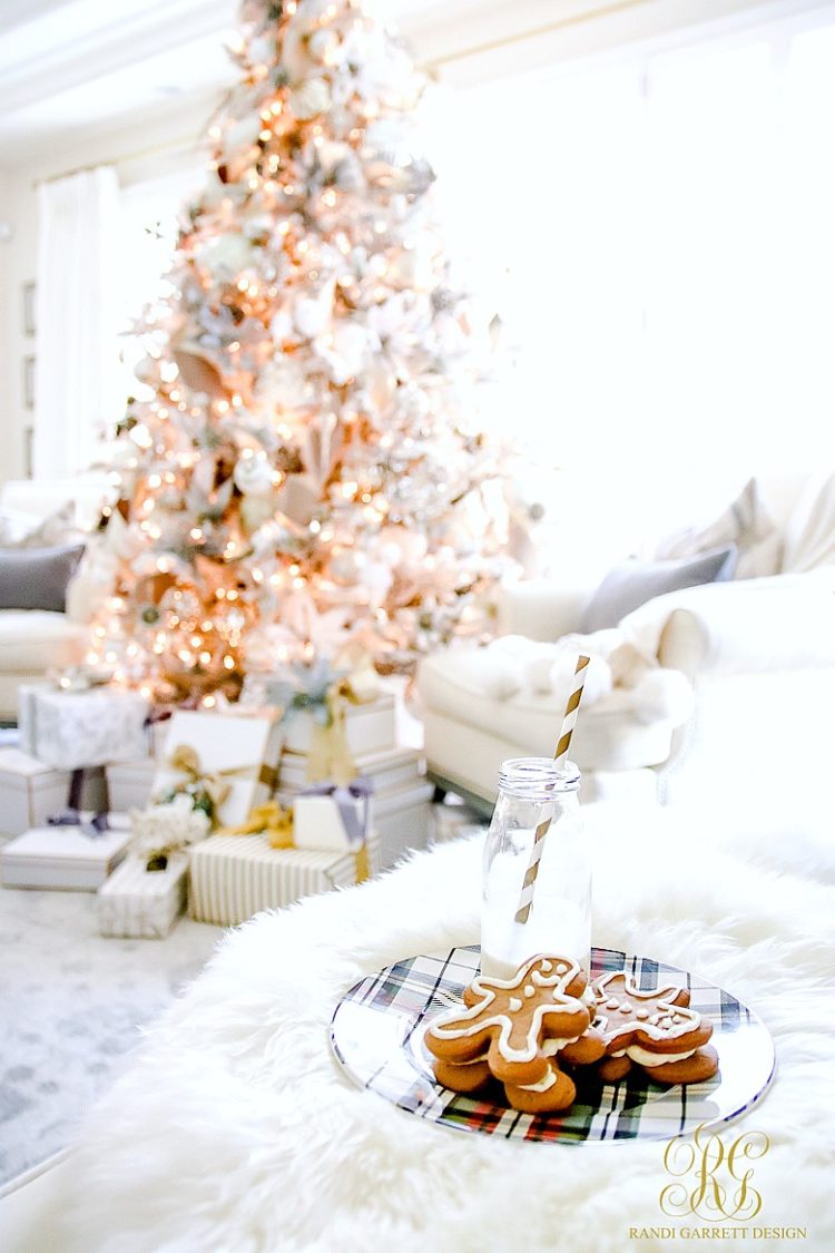 White flocked tree, and gingerbread cookies beside the tree.