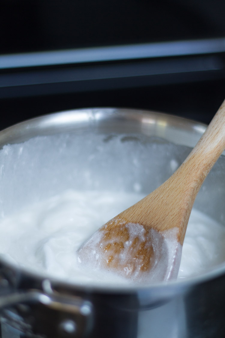 The sugar coconut mixture in a slow boil on the stove.