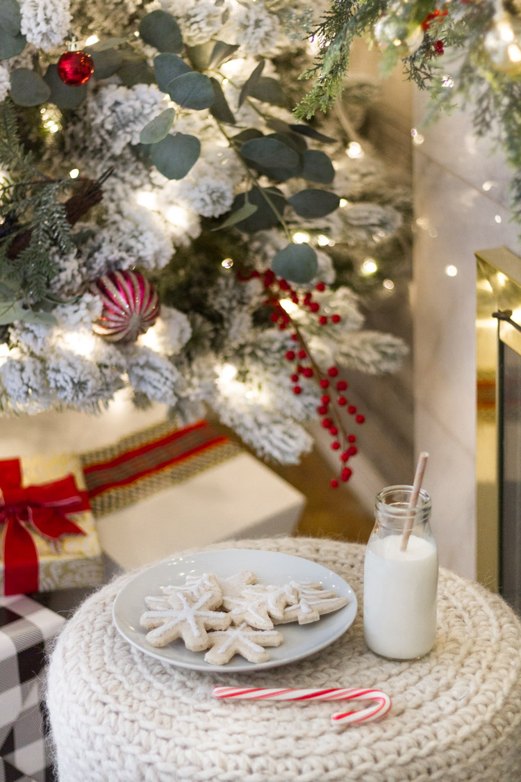 Decorated Christmas tree with a plate of sugar cookies and milk in front of it.