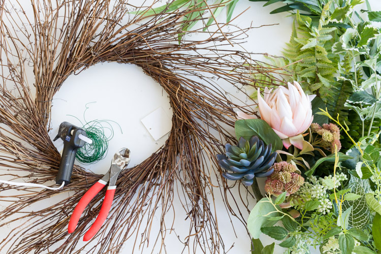 The wreath with a hot glue un, and the greenery ready to go on the counter.