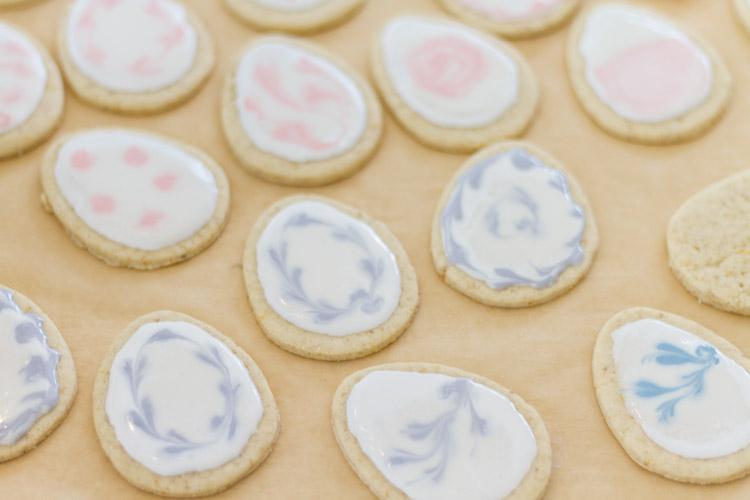Iced cookies with blue and pink designs on them.