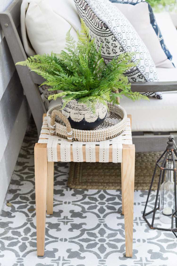 The table outdoor on the patio with a green plant on it.