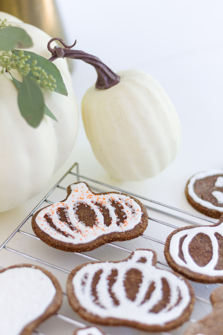 The decorated pumpkin cookies with white frosting and orange sprinkles.