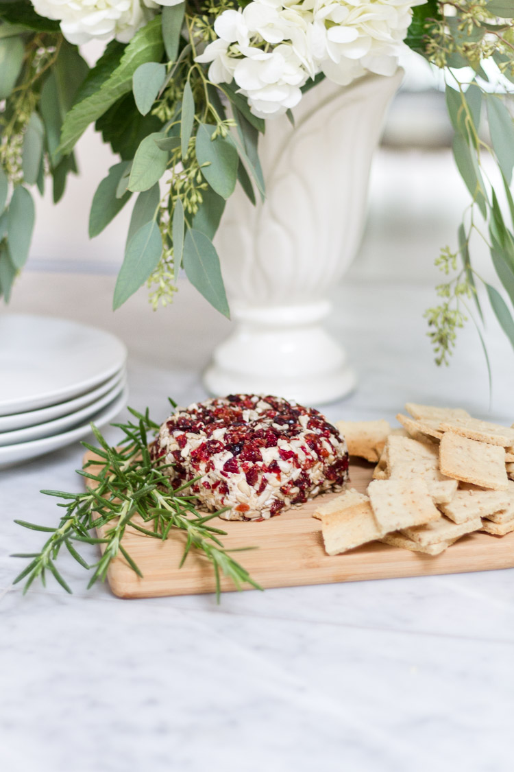 Vegan Cranberry Cheese Loaf with Almond Crackers on a wooden cutting board.