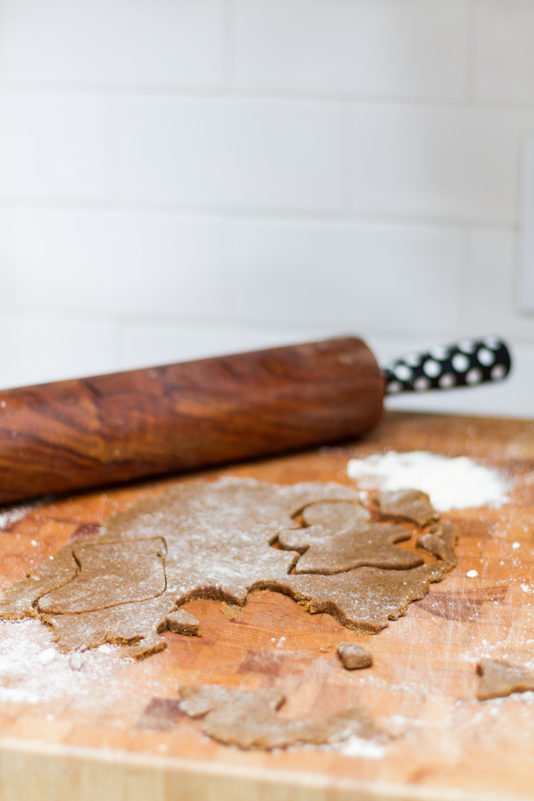 A rolling pin, cookie cutter shapes and flour on the counter.