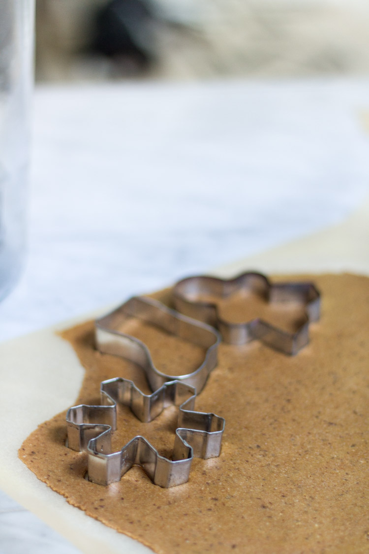 Cookie cutters cutting out the the rolled out dough.