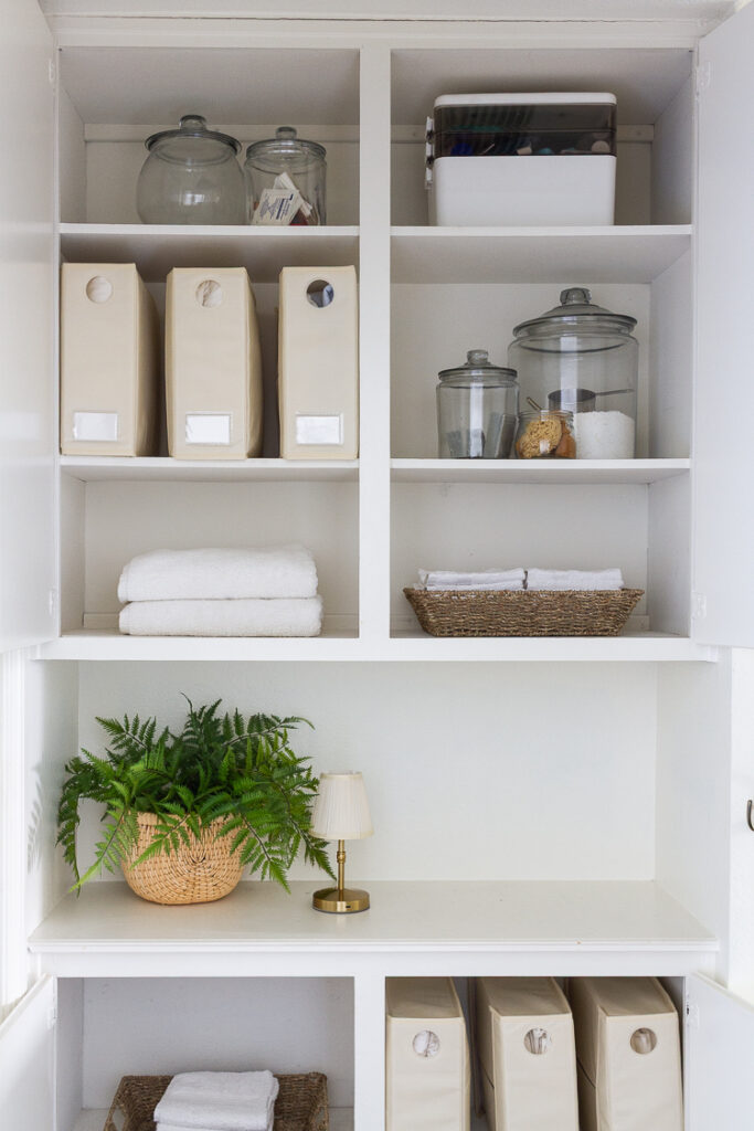 organized linen closet with towel, baskets and guest essentials.